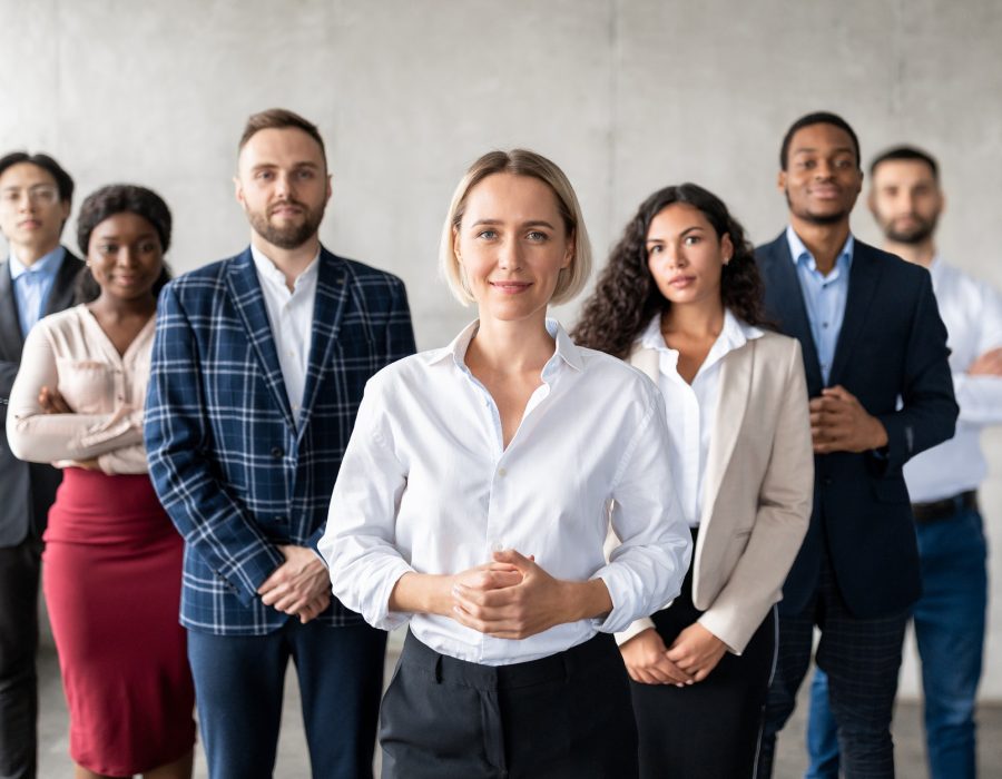 successful-businesswoman-standing-in-front-of-business-team-in-office.jpg